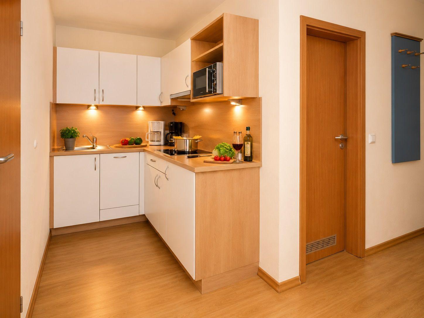 Kitchen with wooden surfaces, white cabinets, and kitchen appliances.