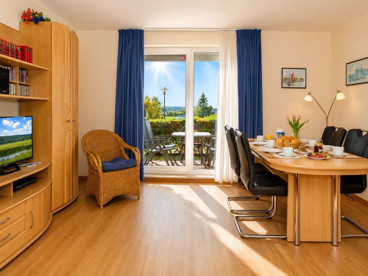 Dining room with table, chairs, and garden view. Left: living area with TV.
