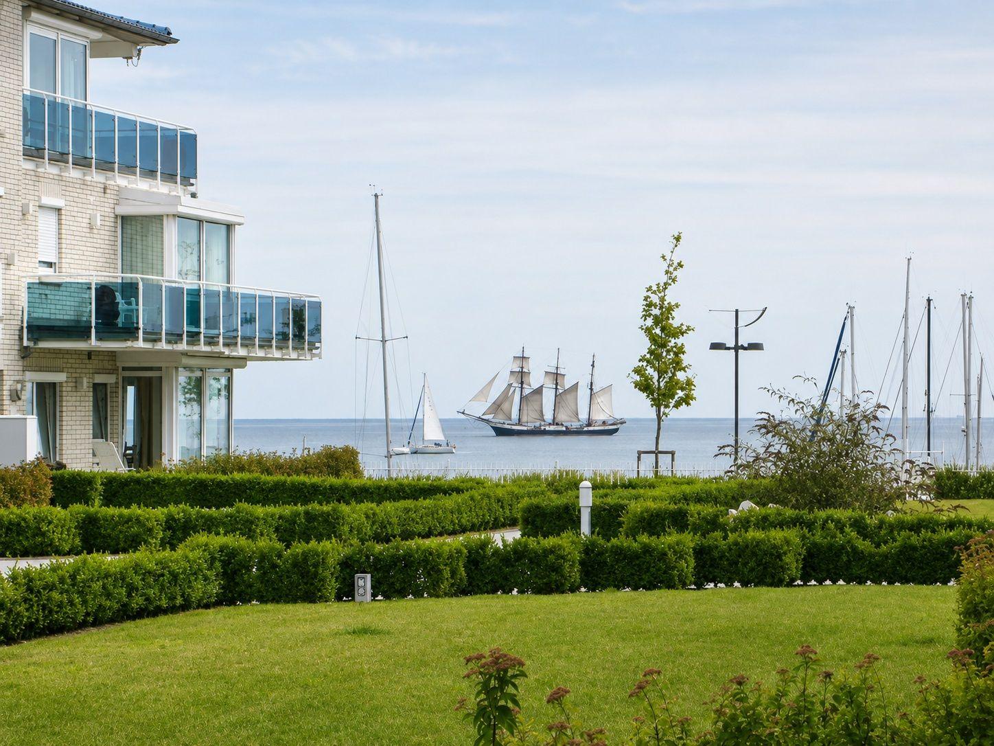 Modernes Gebäude mit Balkonen, Blick auf das Meer und Segelboote.