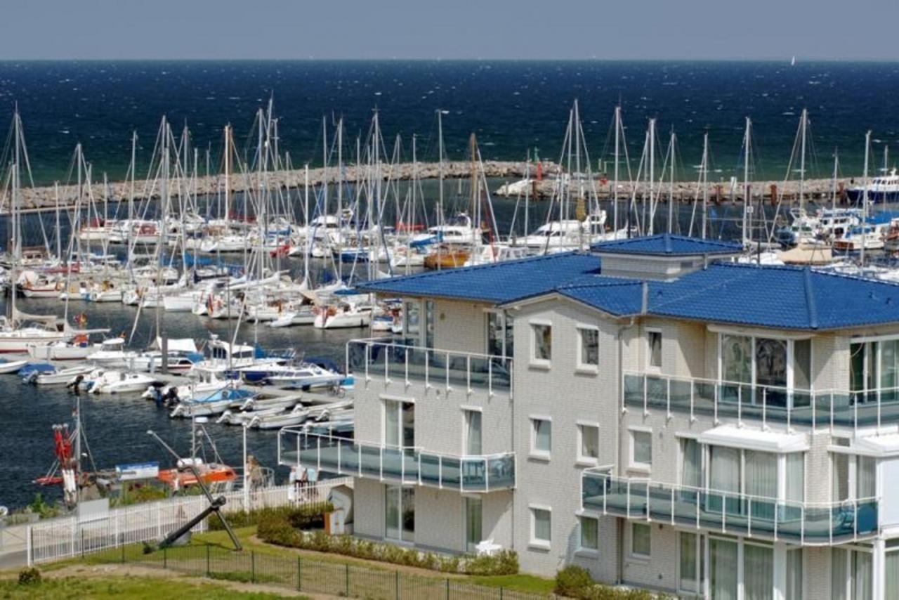 Moderne Wohnung mit Balkon und Blick auf Hafen mit Segelbooten und Meer.
