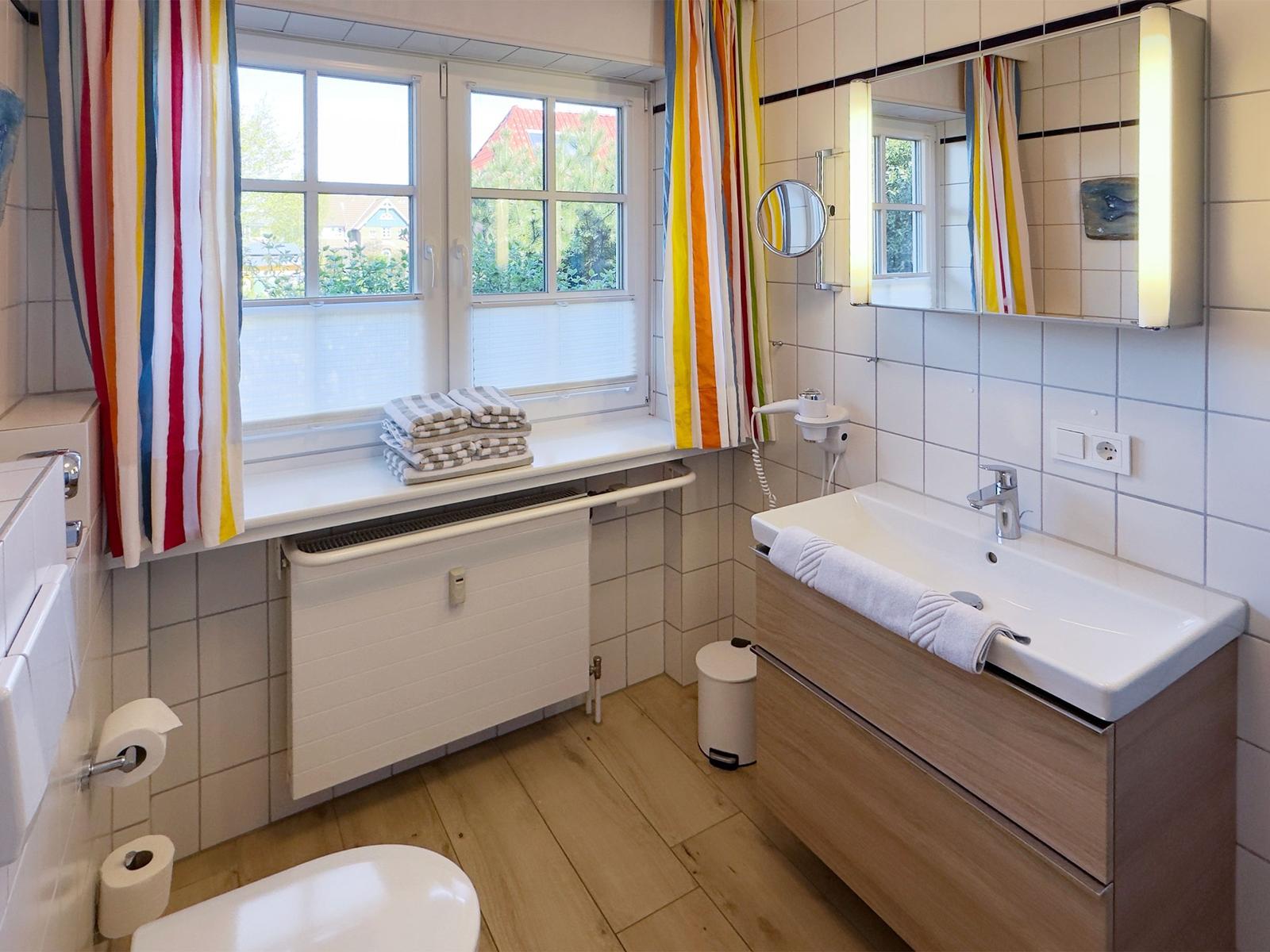 Badezimmer mit Fenster, Waschbecken und Toilette. Badezimmer mit Fenster, Waschbecken und Toilette.