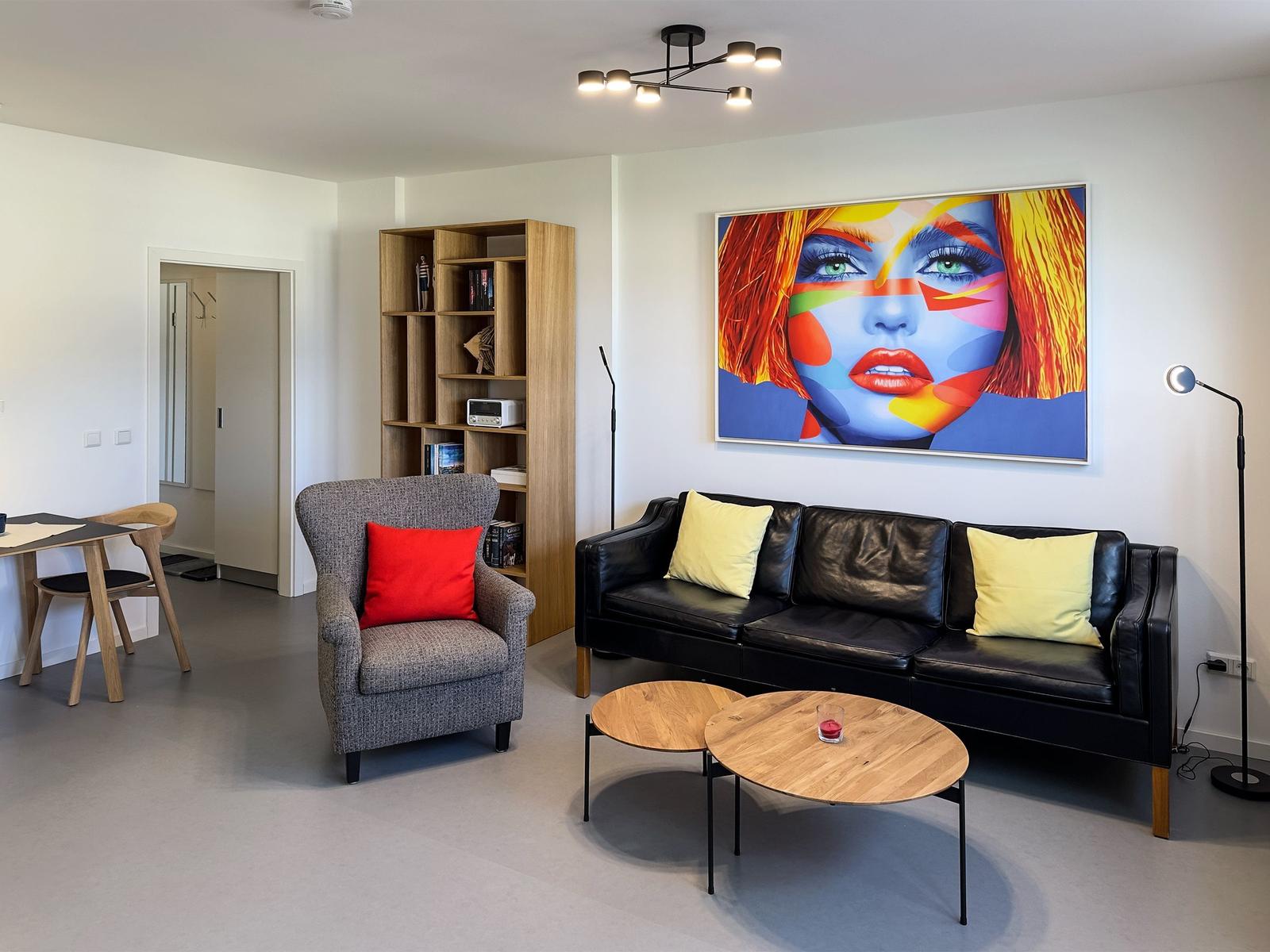 Living room with sofa, armchair, table, and wall art