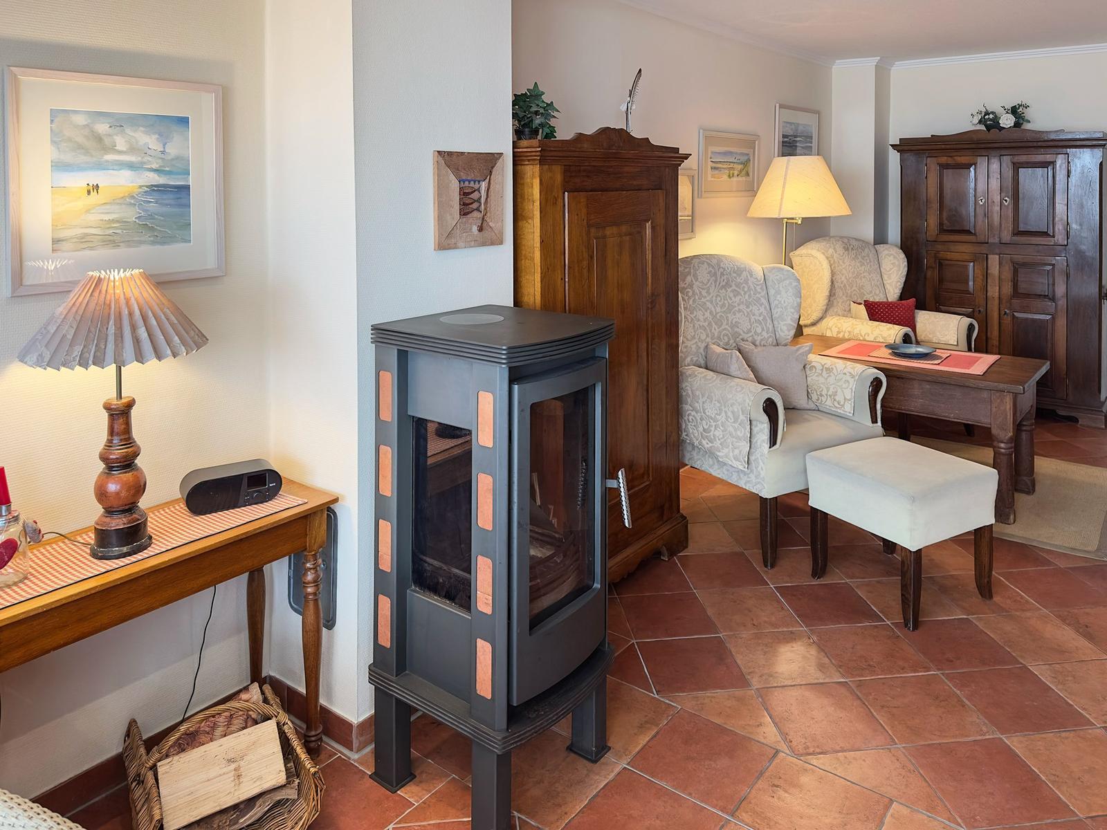 Wohnzimmer mit Kamin, Holzmöbeln und Terrakottaboden.