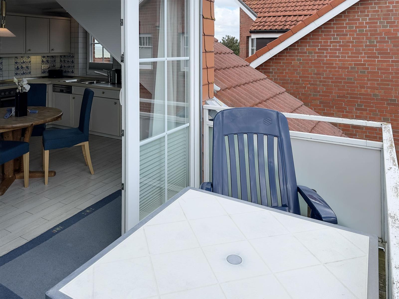 Terrasse mit Tisch und Stuhl, Blick in die Küche mit Esstisch.