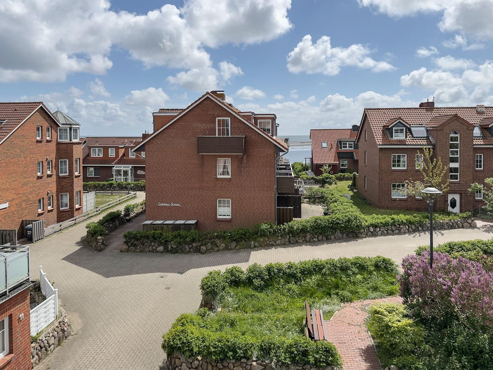 Rotes Backsteingebäude mit Terrasse und Blick aufs Meer.