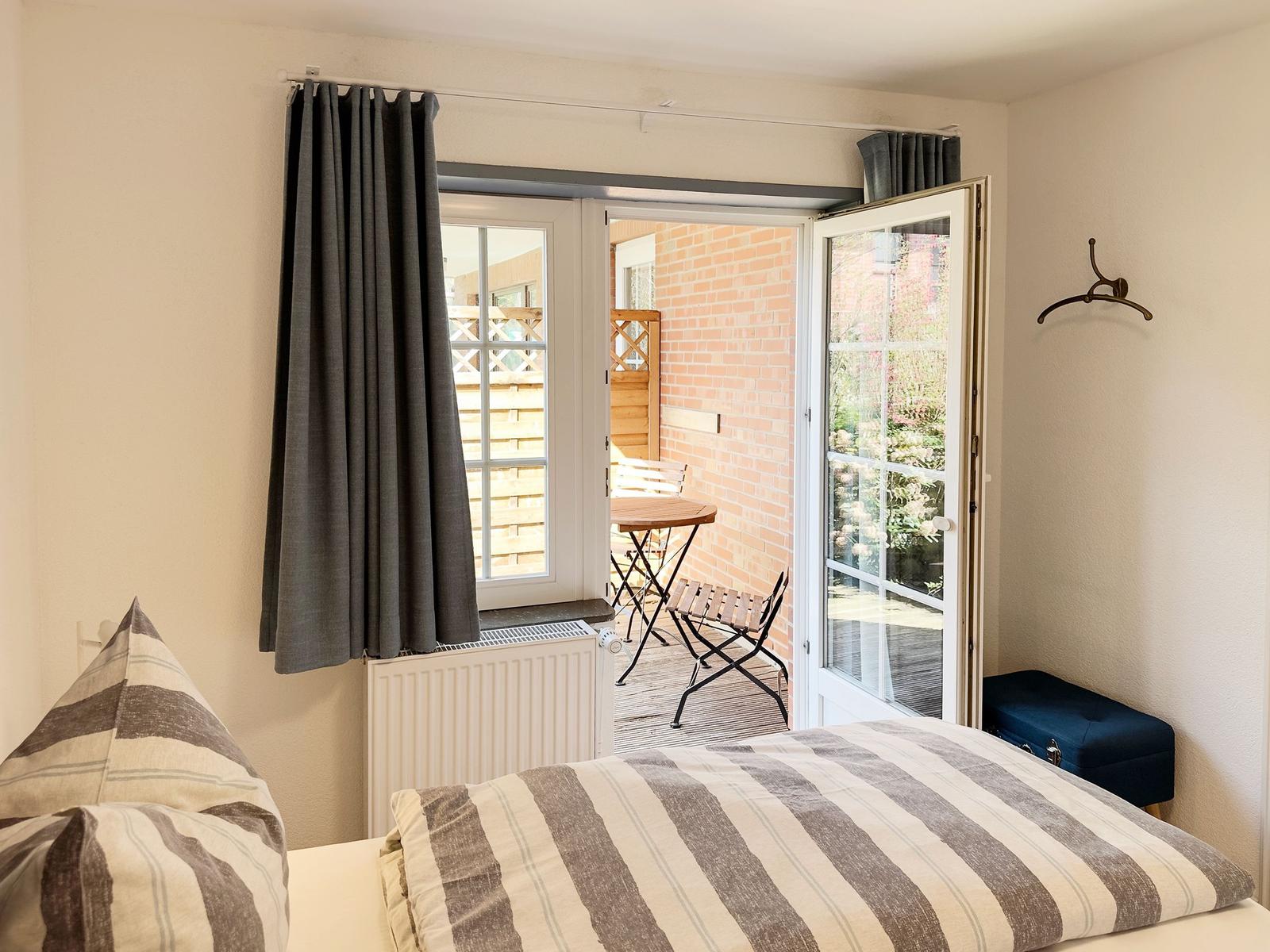 Schlafzimmer mit Blick auf Terrasse und Garten