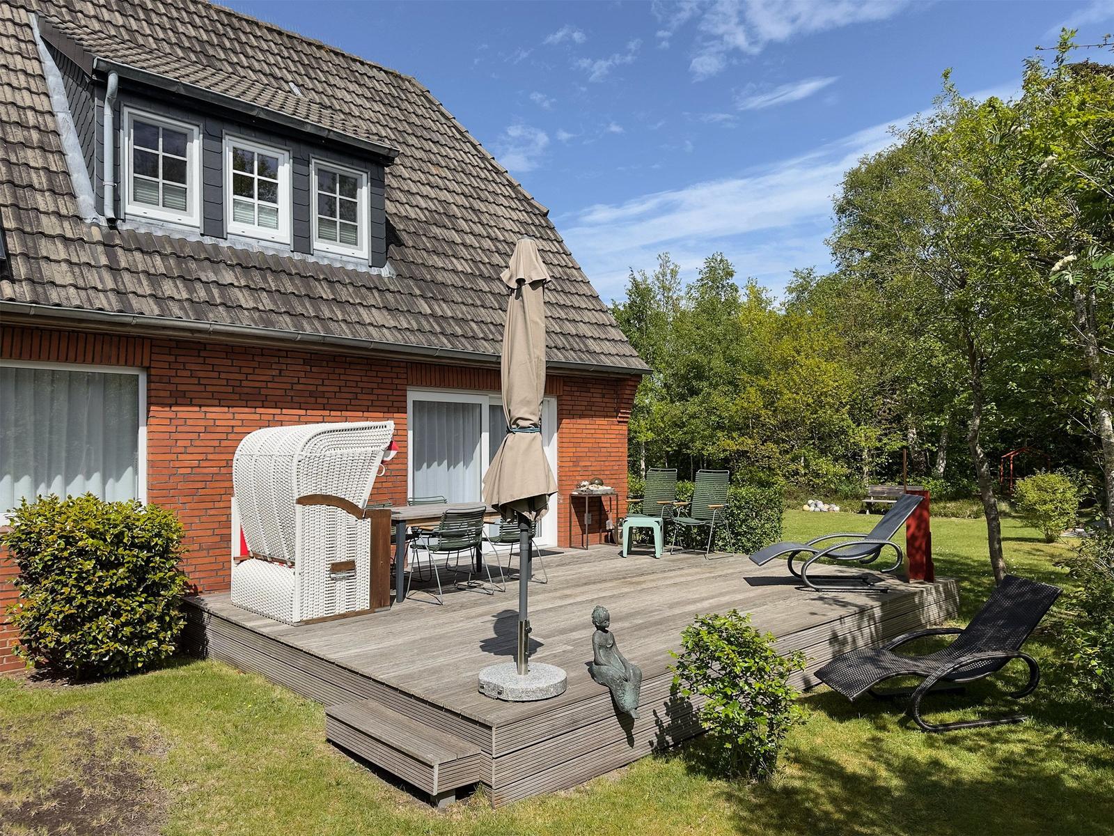Haus mit Terrasse, Gartenmöbeln und Sonnenschutz