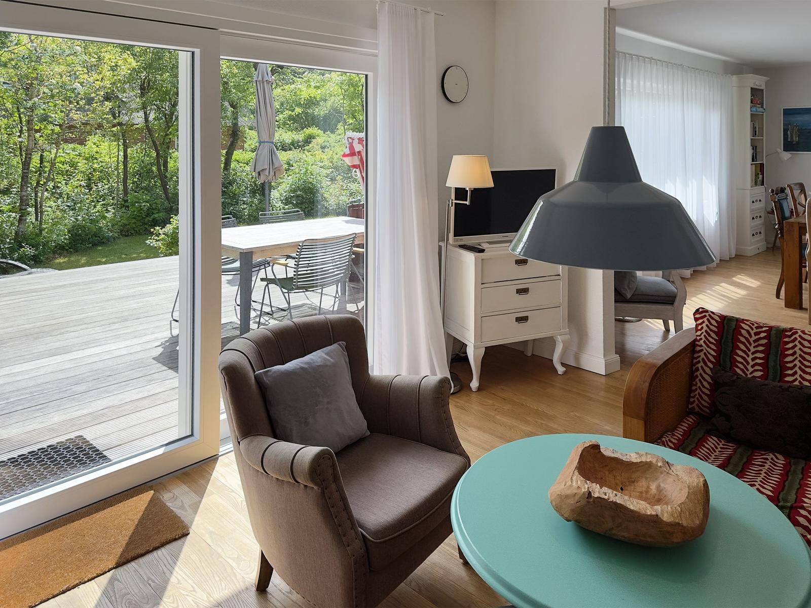 Wohnzimmer mit Sitzgelegenheiten und Blick auf die Terrasse