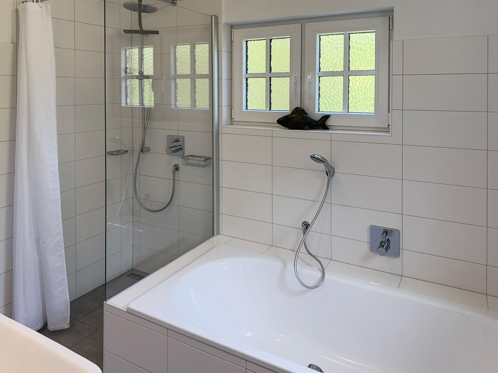 Bad mit Dusche und Badewanne, Fenster mit grünem Glas.