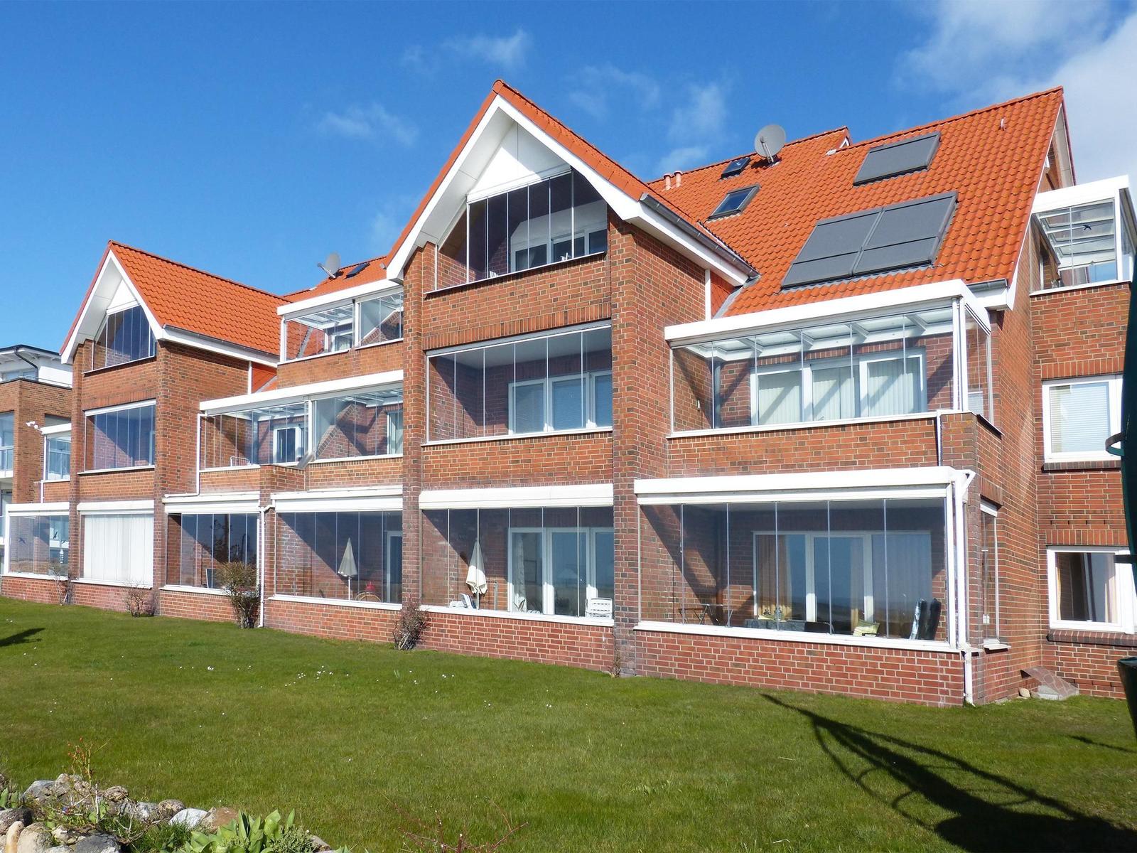Rotes Ziegelhaus mit Glasveranda und Solaranlage auf Dach