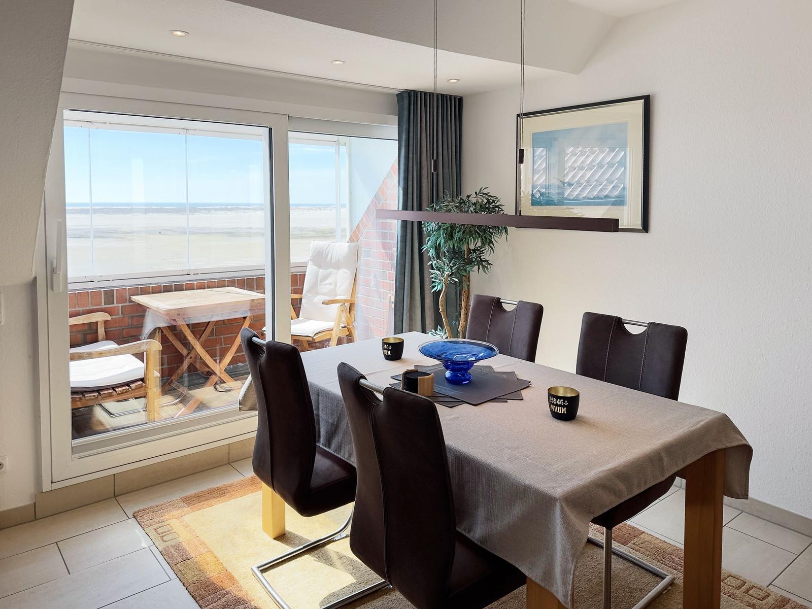 Esstisch mit Stühlen und Blick auf den Strand