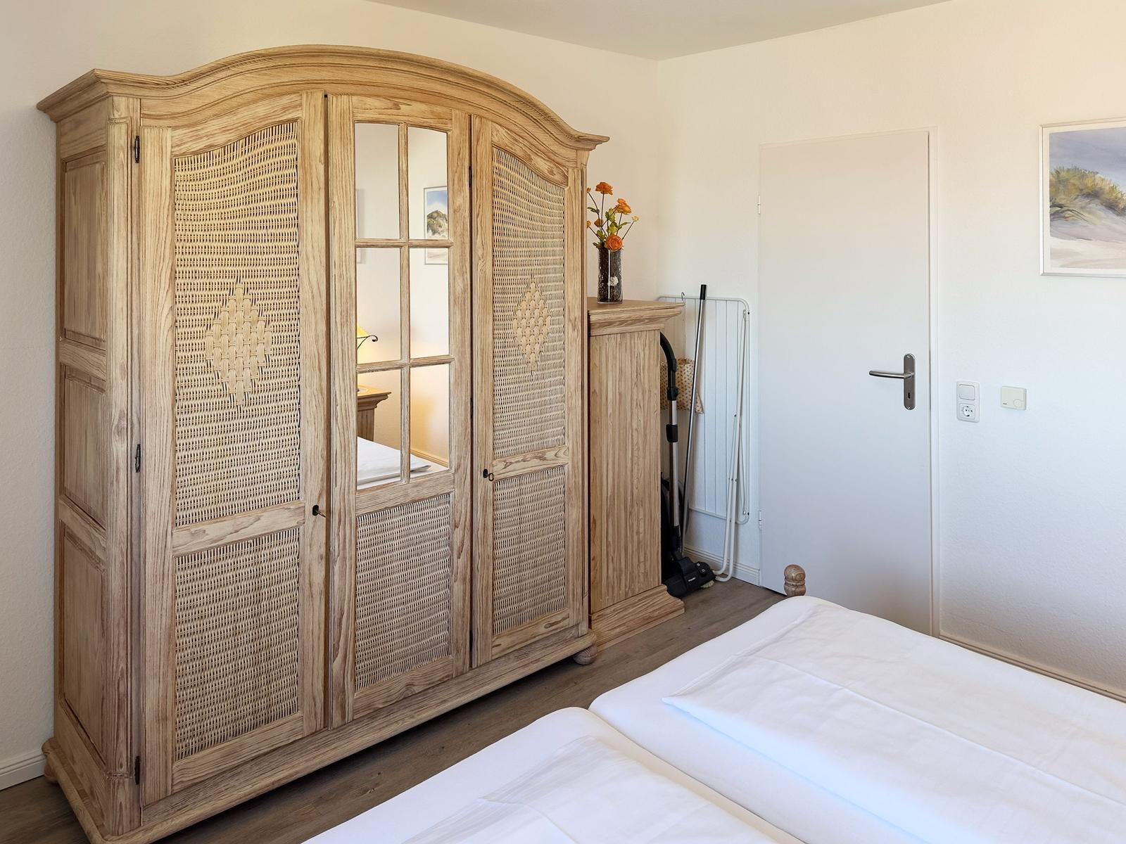 Schlafzimmer mit Holzschrank, Bett und Tür