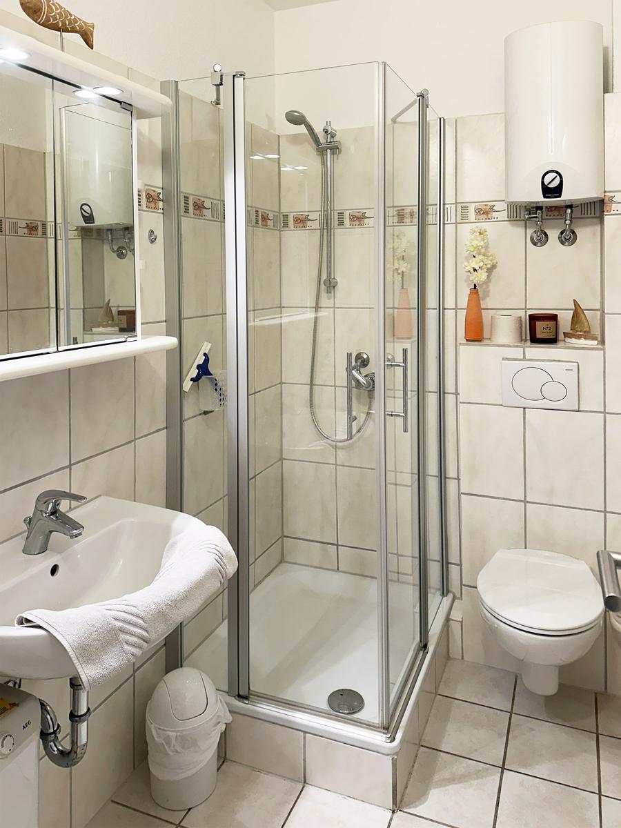 Badezimmer mit Dusche, Waschbecken und Toilette