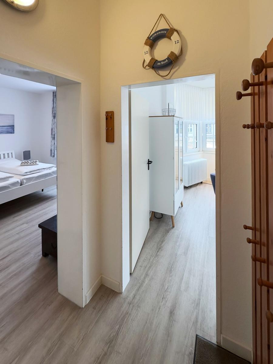 Flur mit Schlafzimmer und Wohnbereich. An der Wand hängt ein Rettungsring.
