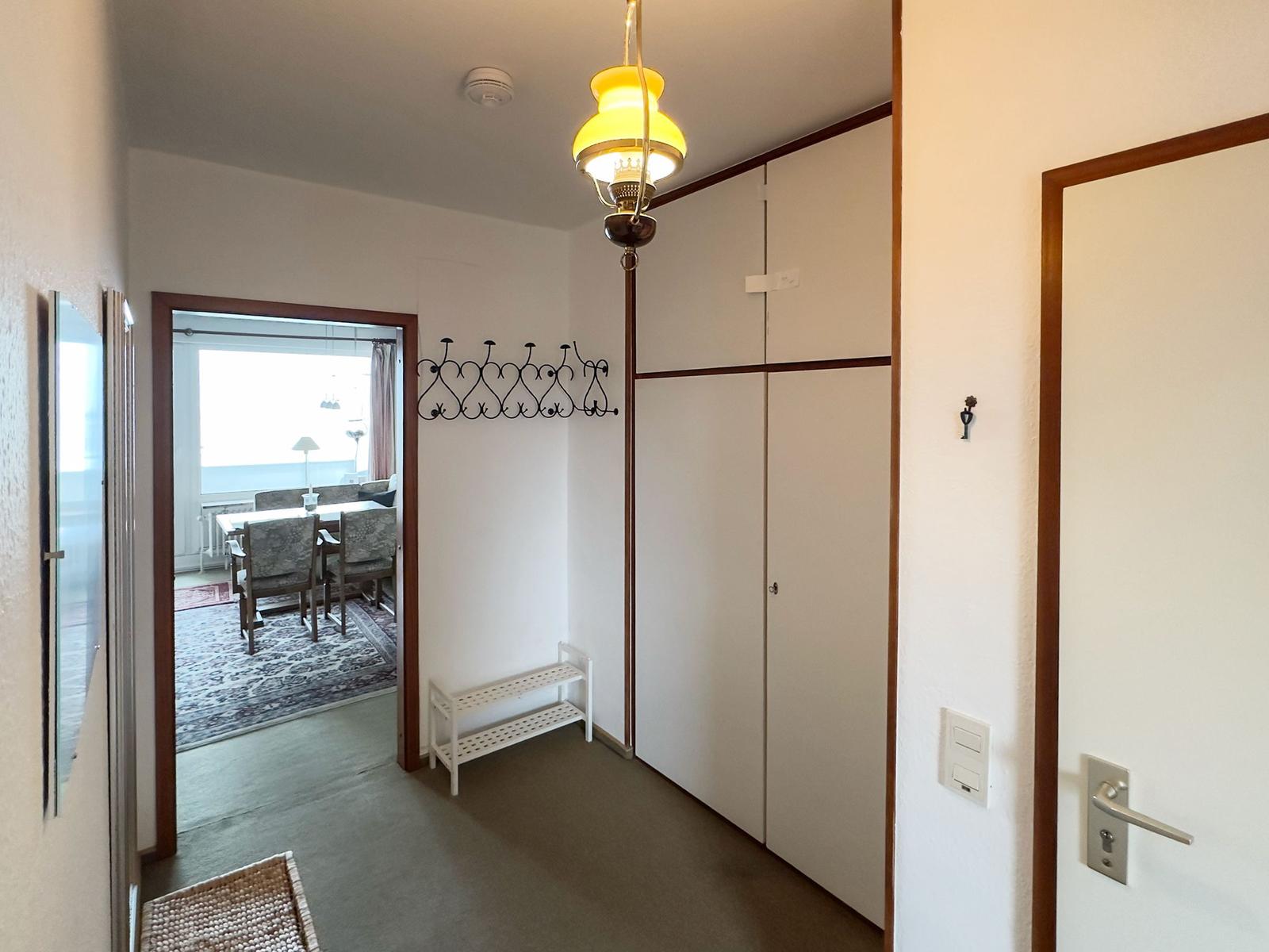Entryway with coat rack, closet, and view into dining room