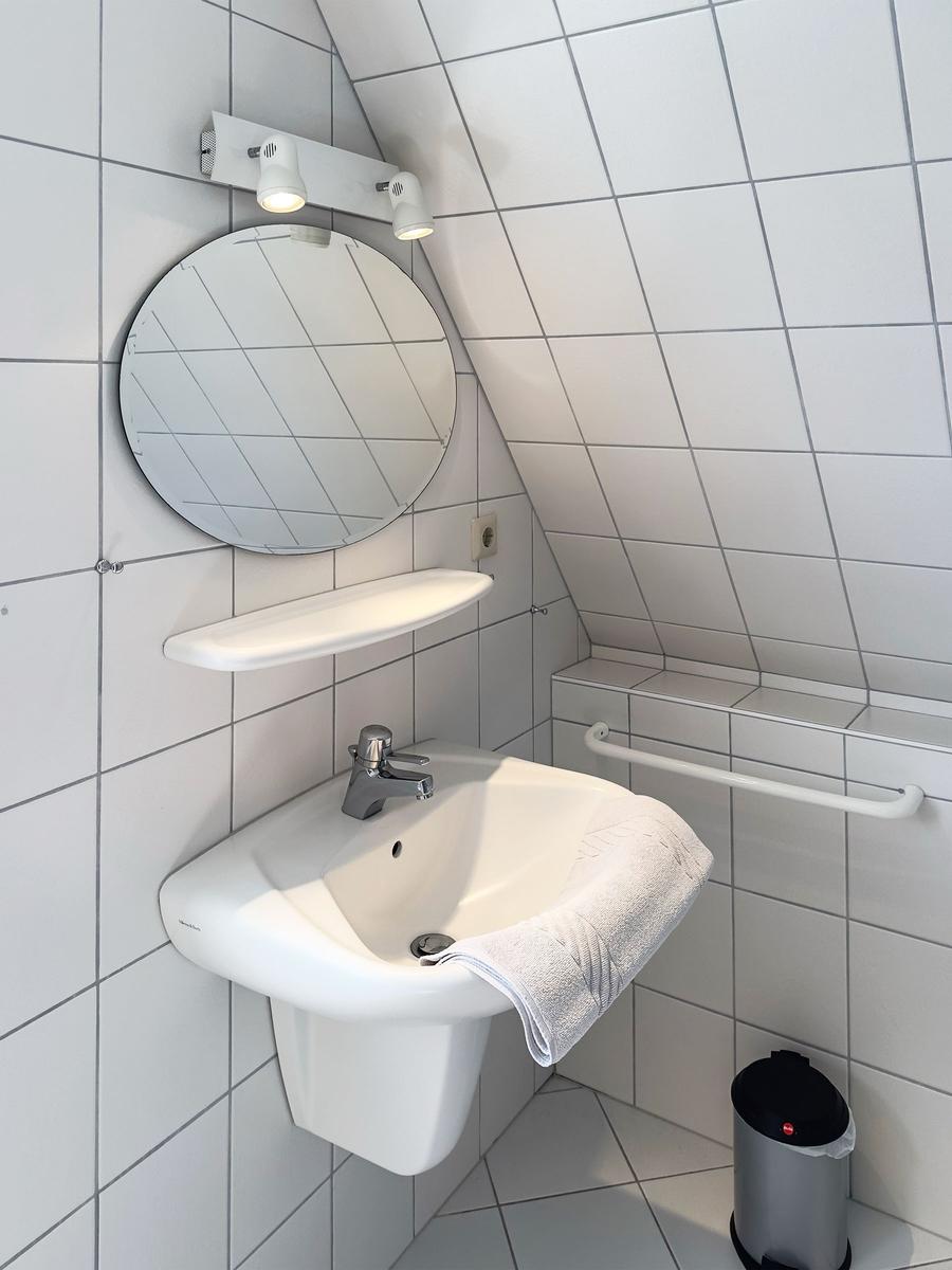 Duschbad mit Waschbecken, Spiegel und Handtuchhalter