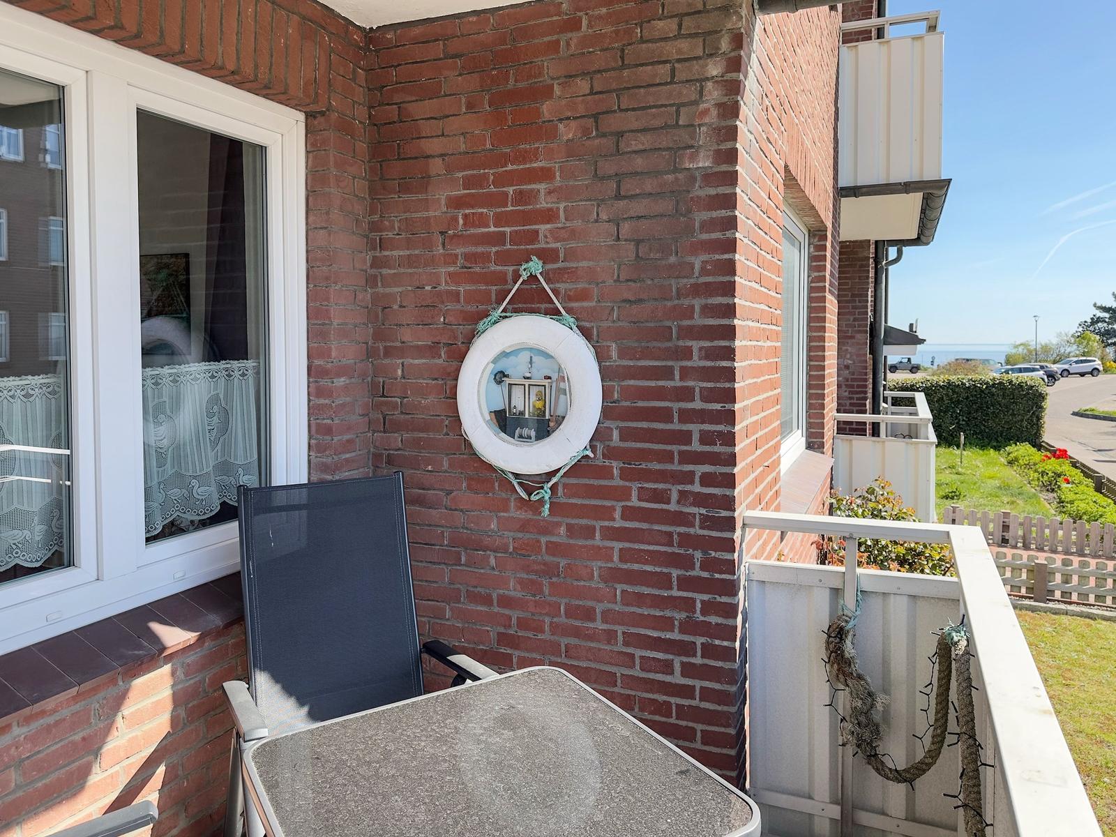 Terrace with chair, table, and lifebuoy on the wall