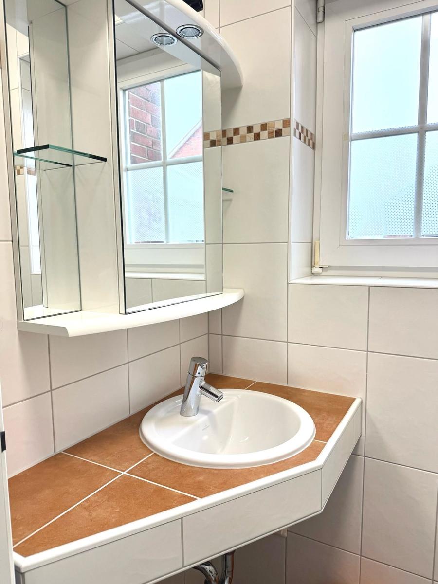 Bad mit Waschbecken, Spiegel und Fenster
