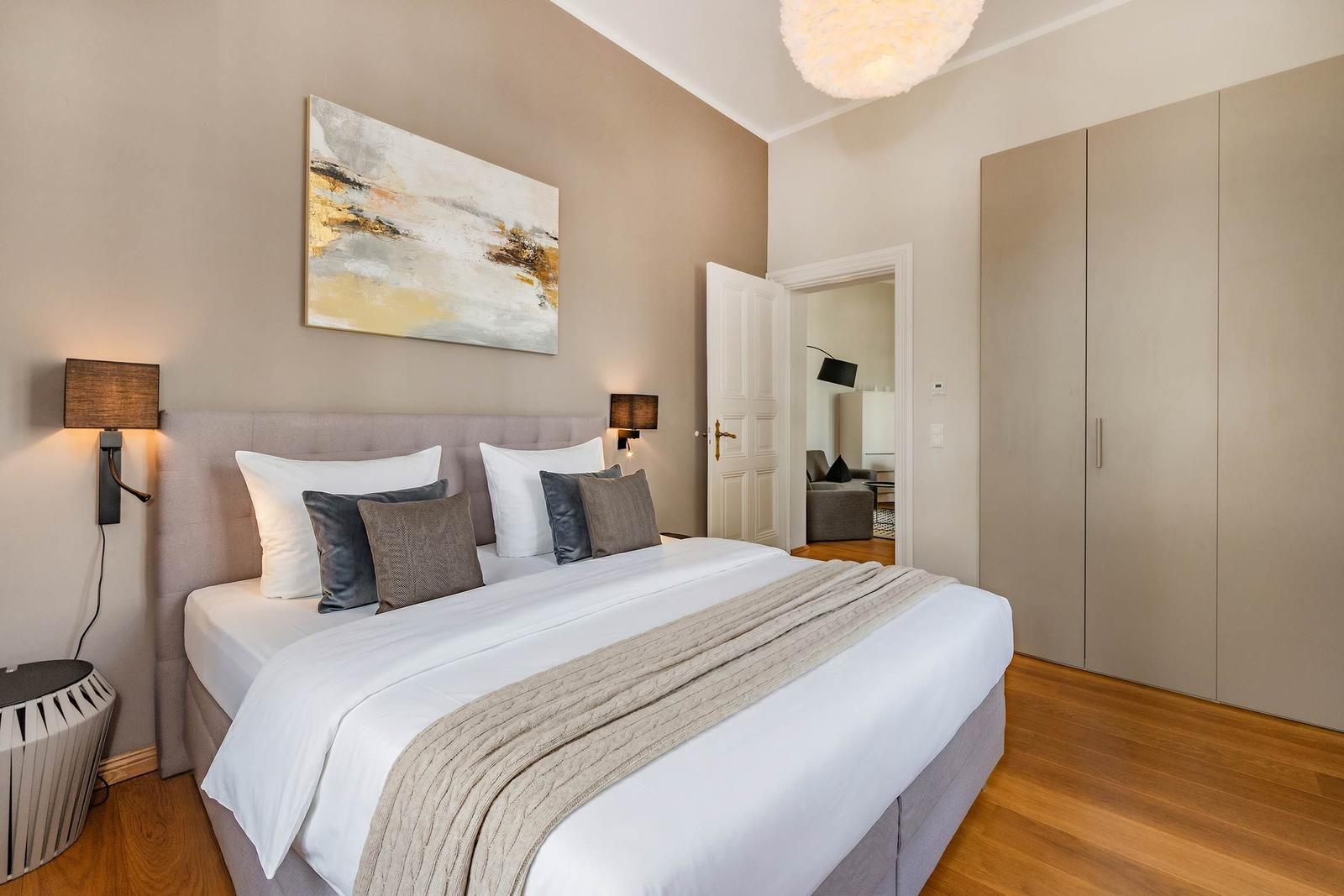 Schlafzimmer mit Bett, Kleiderschrank und Wandbild.
