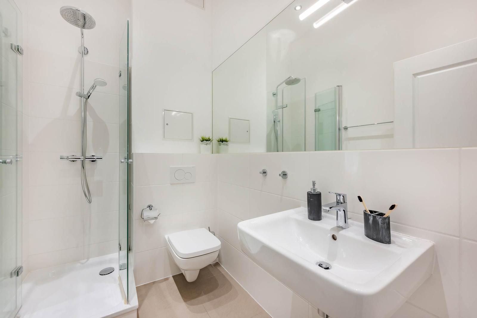 Badezimmer mit Dusche, Waschbecken und Toilette.