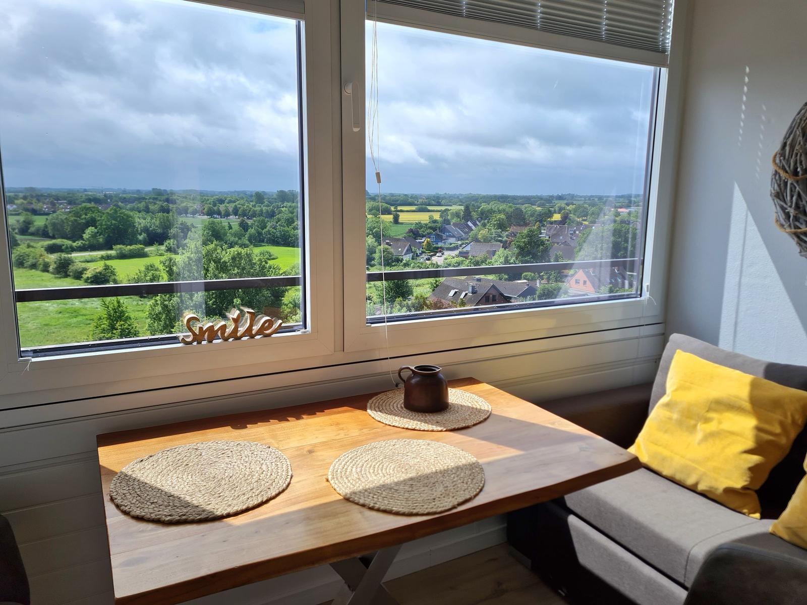 Tisch mit Platzset und Aussicht auf grüne Landschaft.
