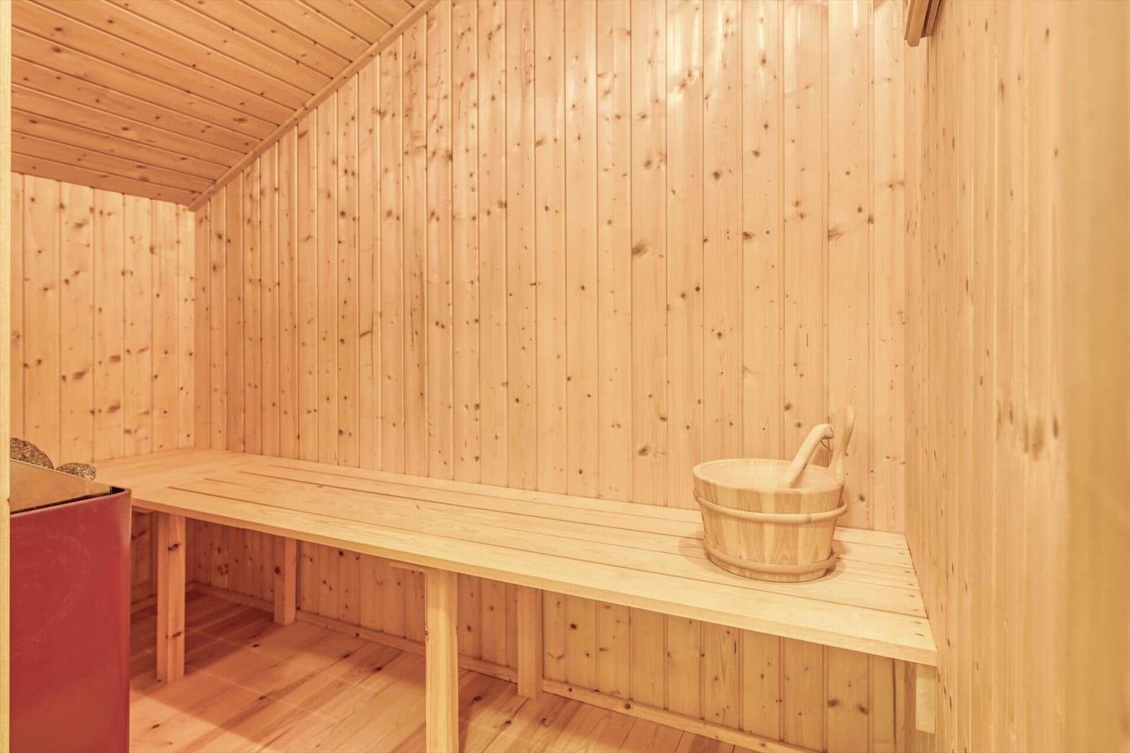 Sauna mit Holzwand, Bank und Eimer