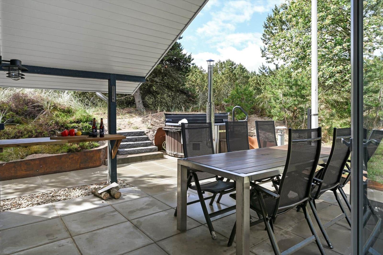 Terrasse mit Tisch, Stühlen und Whirlpool im Grünen