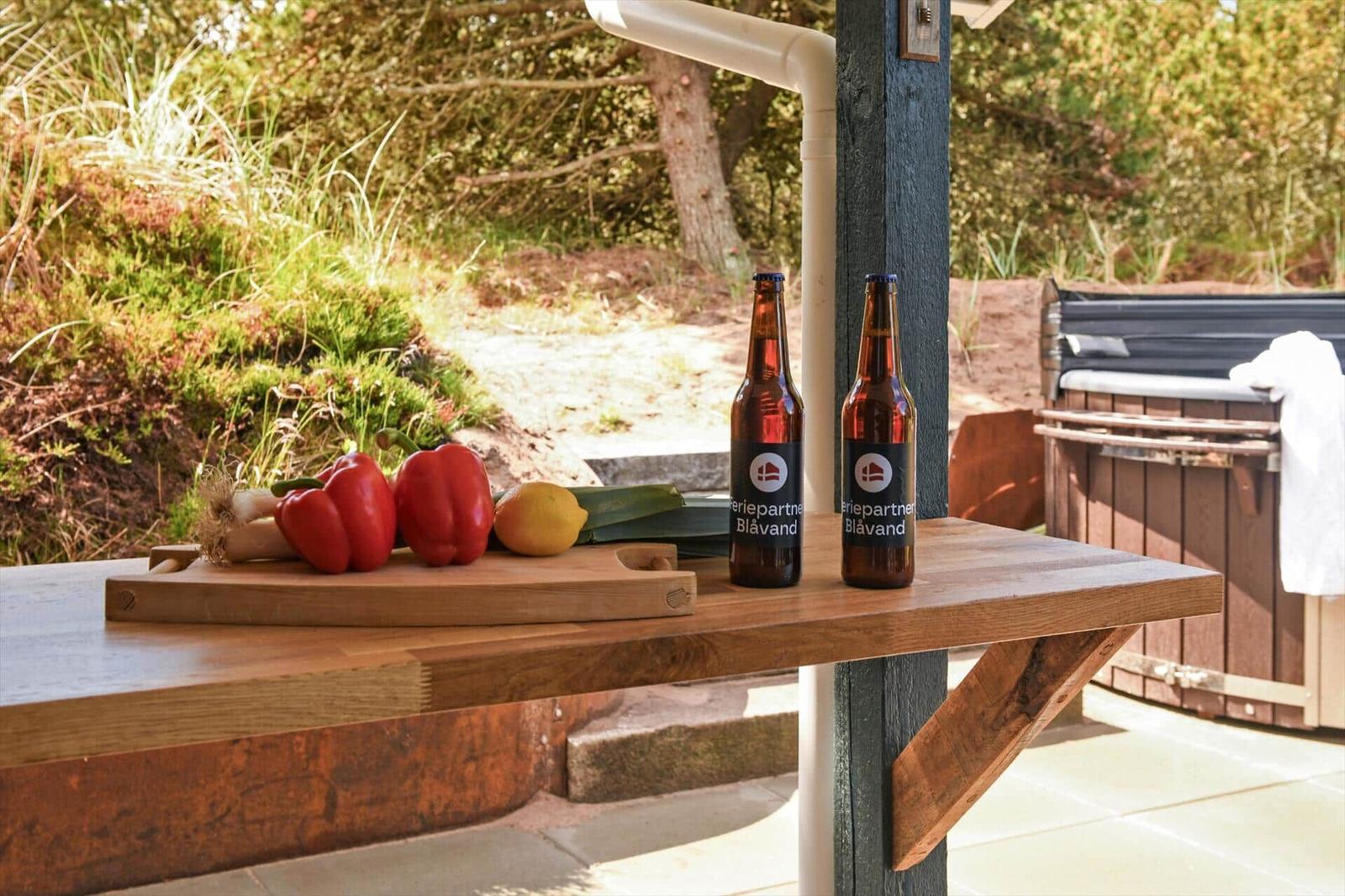 Holztisch mit Gemüse und Bierflaschen im Außenbereich