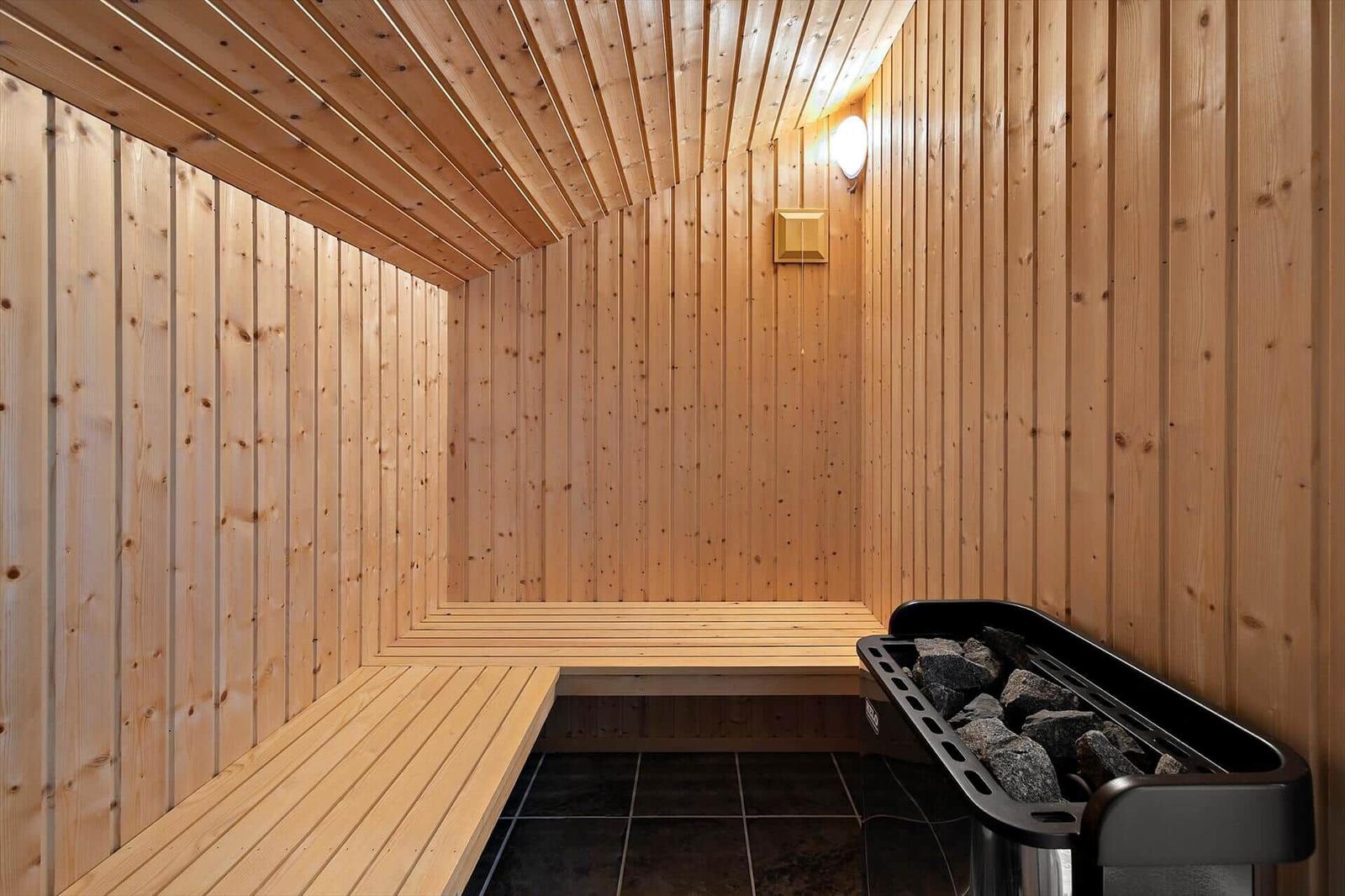 Sauna mit Holzwandverkleidung und Steinkachelofen