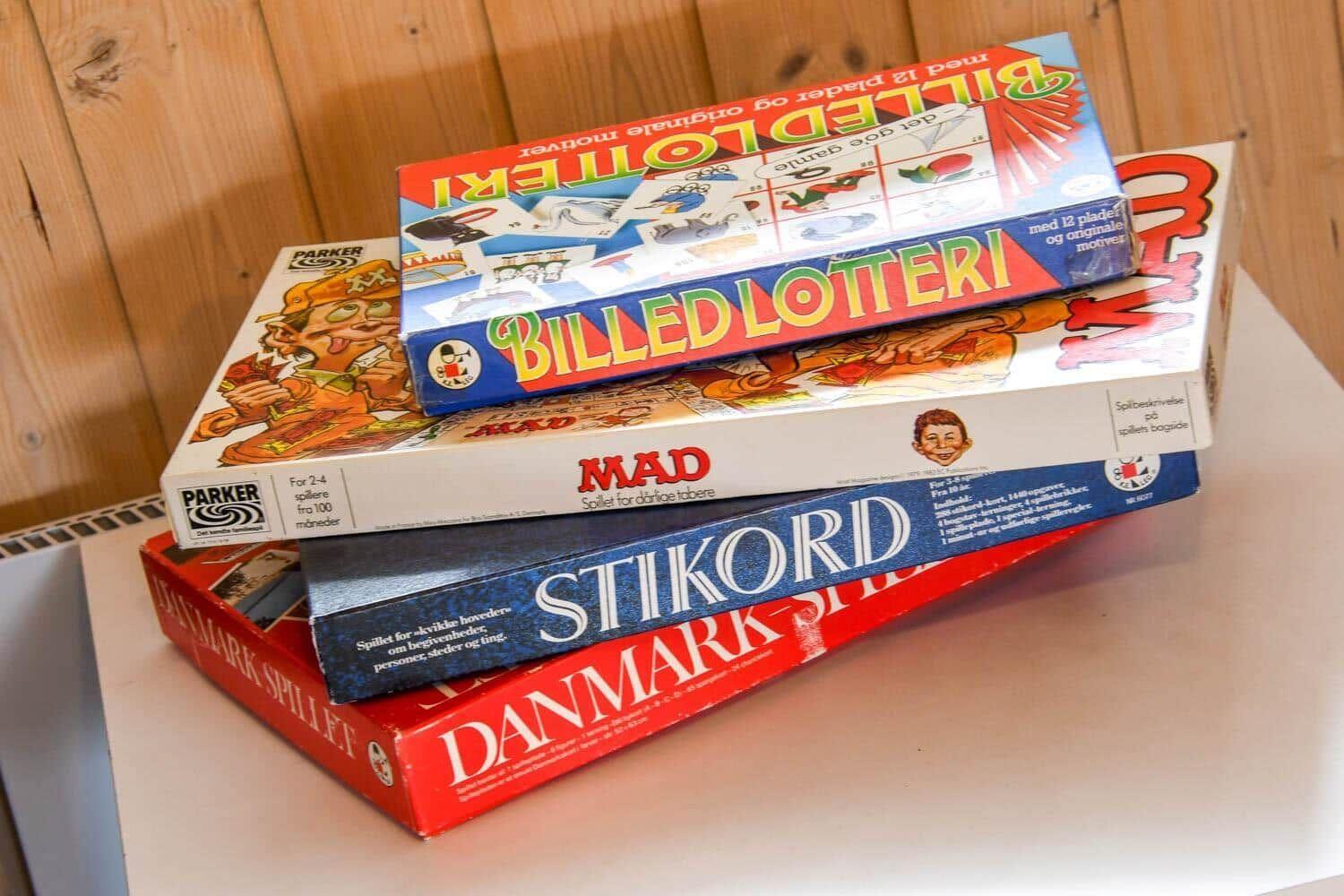 Stapel von Brettspielen auf einer Oberfläche vor Holzwand