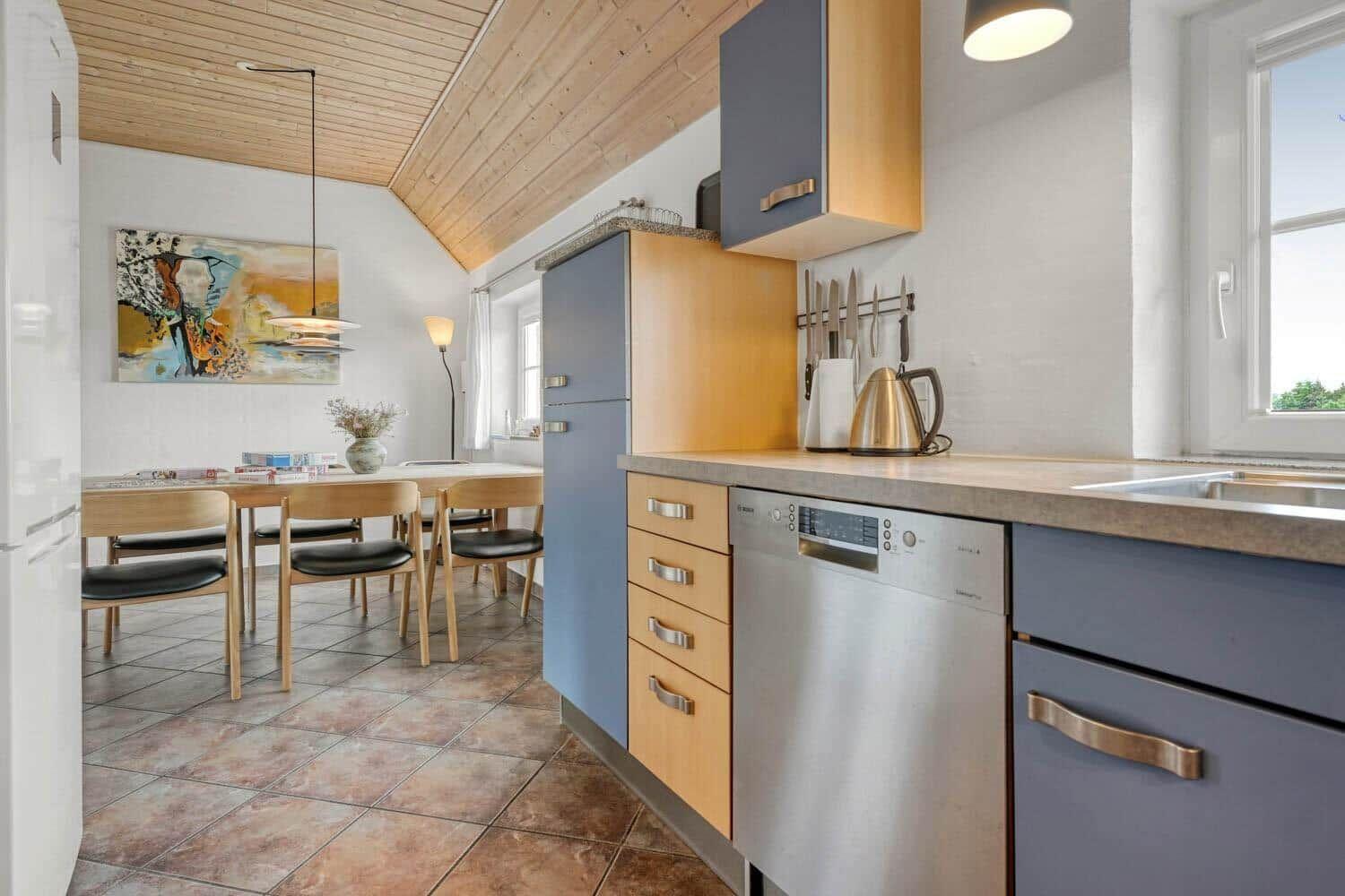 Küche mit Essbereich, Holzdecke und modernen Geräten.