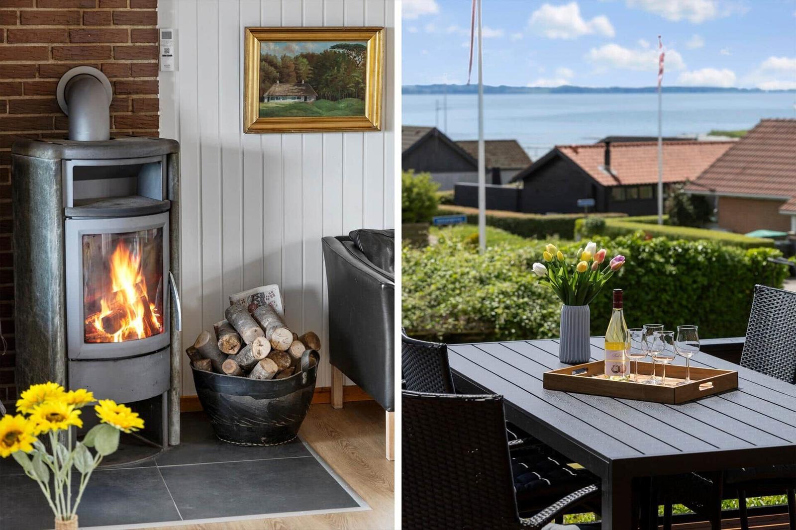 Innenraum mit Kamin und Holzstapel. Außenbereich mit Tisch, Blumen und Meerblick.