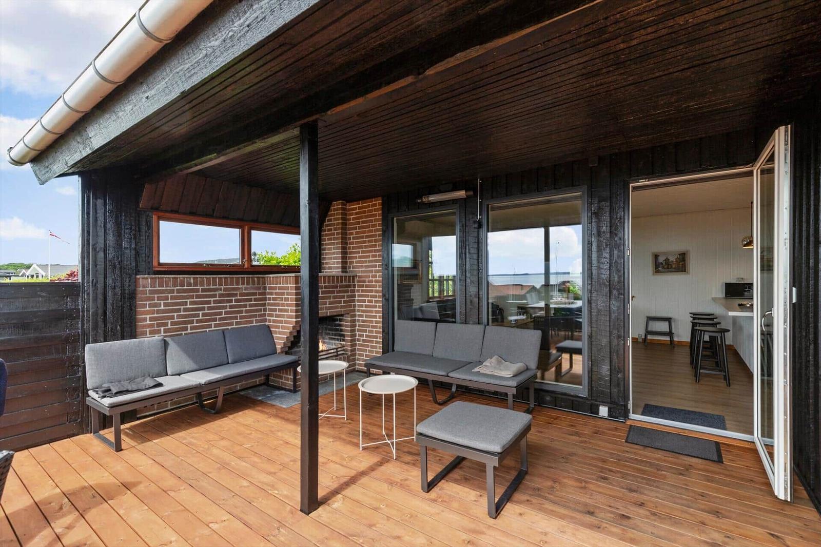 Terrasse mit Sitzgelegenheiten und Blick aufs Meer. Durchgang ins Haus.