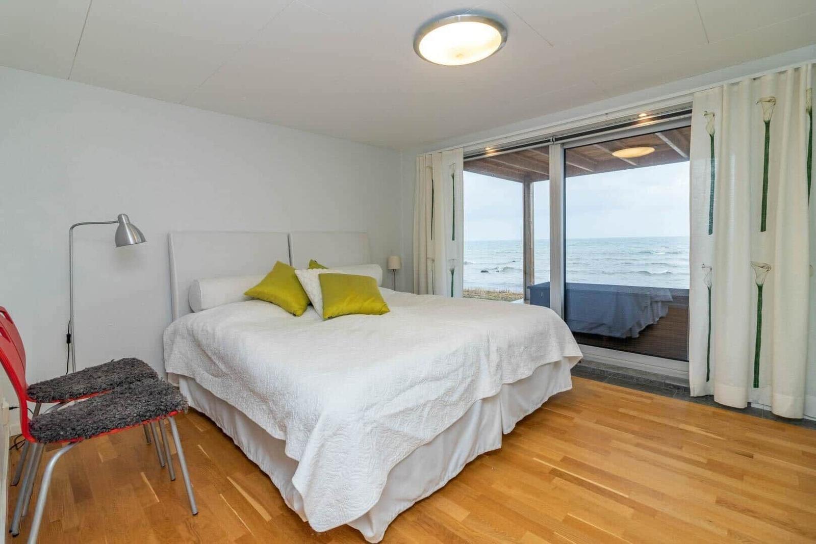 Schlafzimmer mit Blick aufs Meer und Holzboden