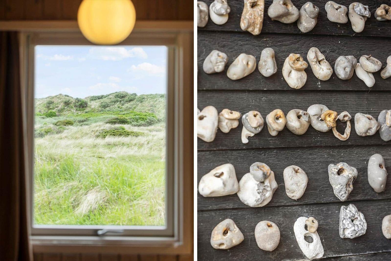 Durch das Fenster Blick auf Grasland und Dünen. An der Wand hängen fossile Zähne.