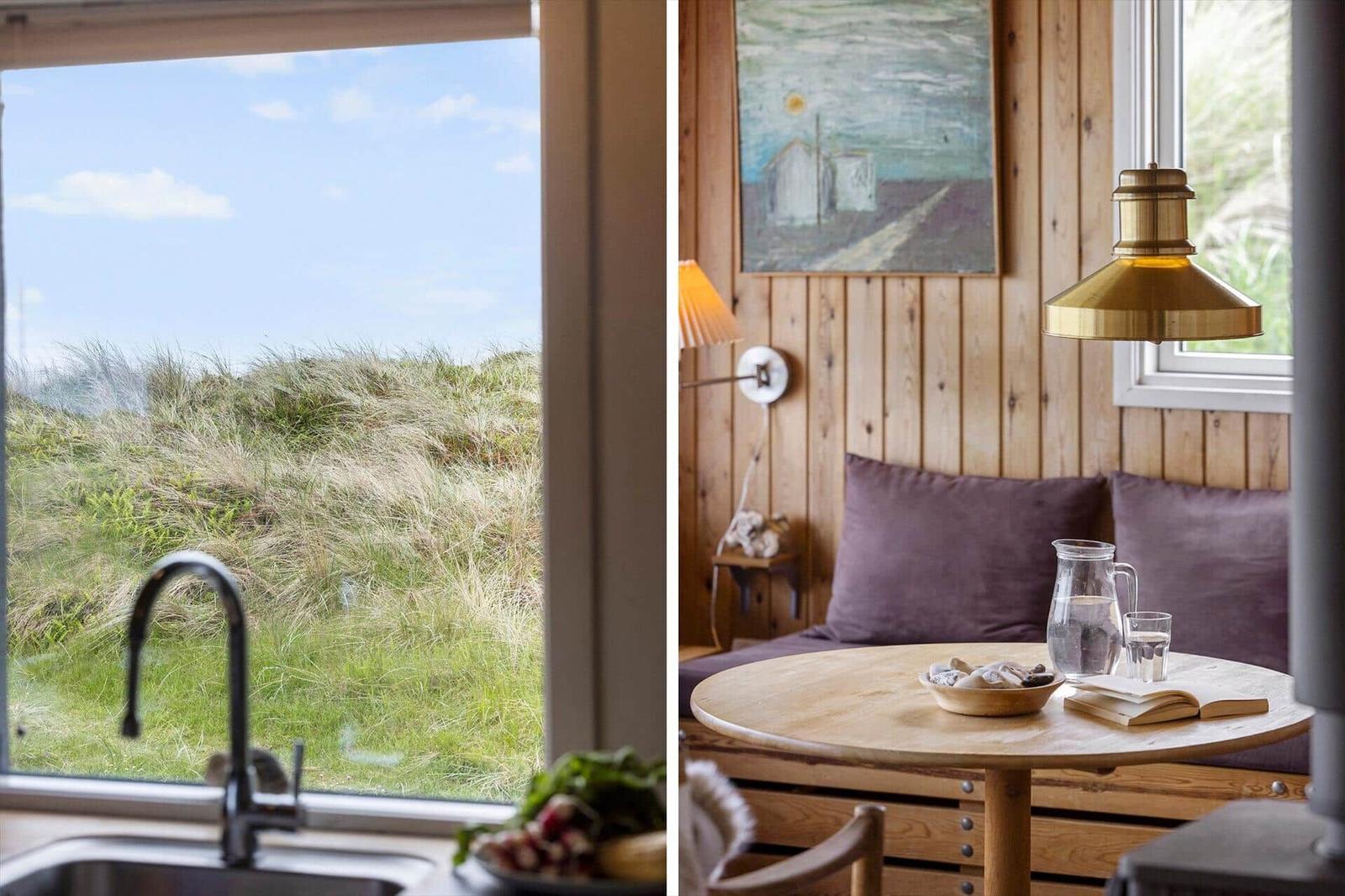 Küche mit Blick auf Grasland. Essbereich mit Holztisch, Stuhl und Wandbild.