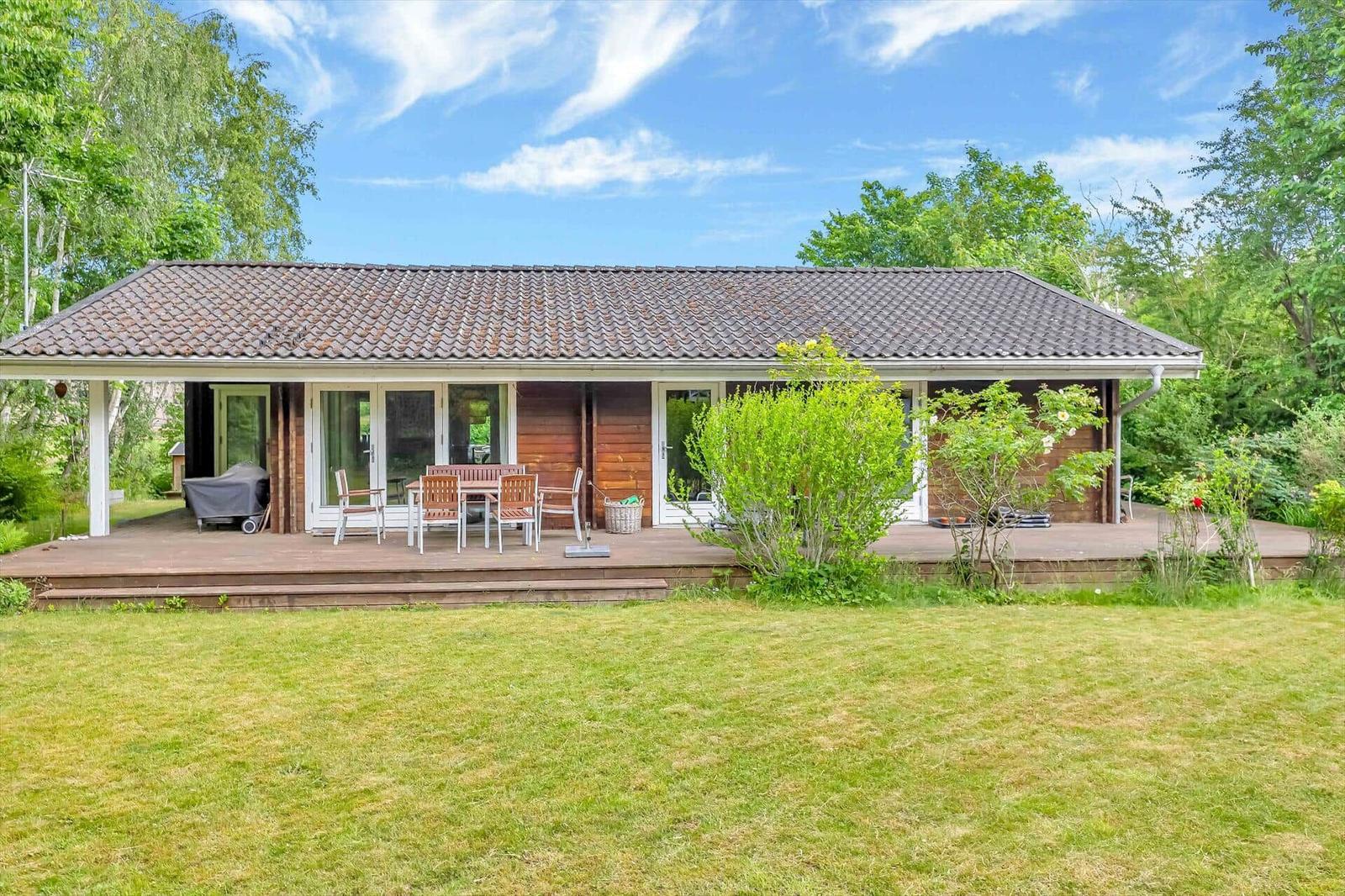 A house with terrace, garden, and seating area outdoors.