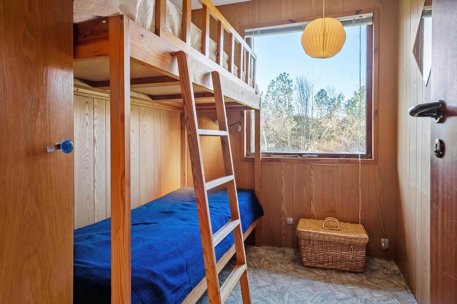 Kammer mit Holz-Bett, Fenster und Korb.