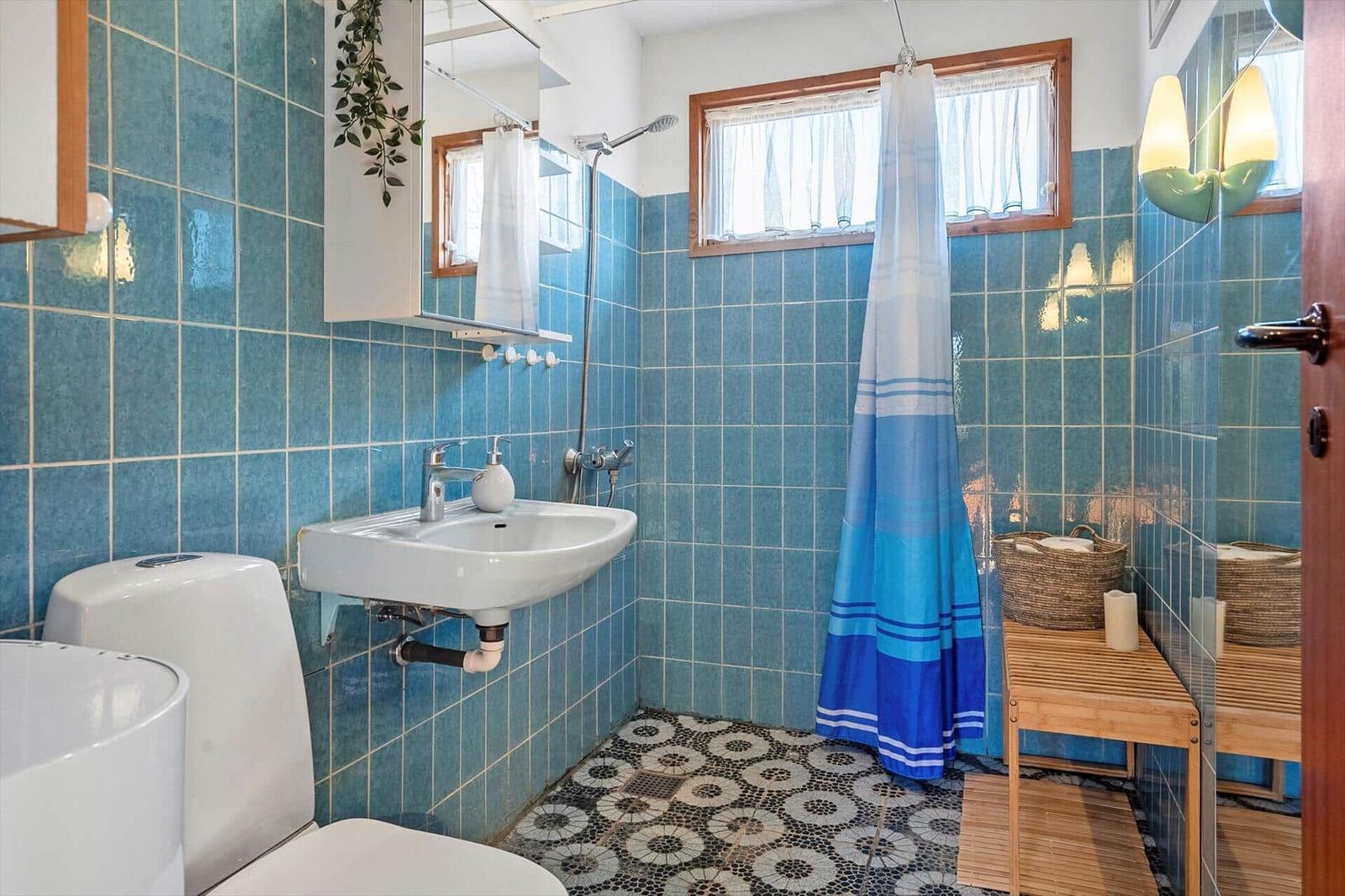 Badezimmer mit blauen Fliesen, Dusche und Waschbecken