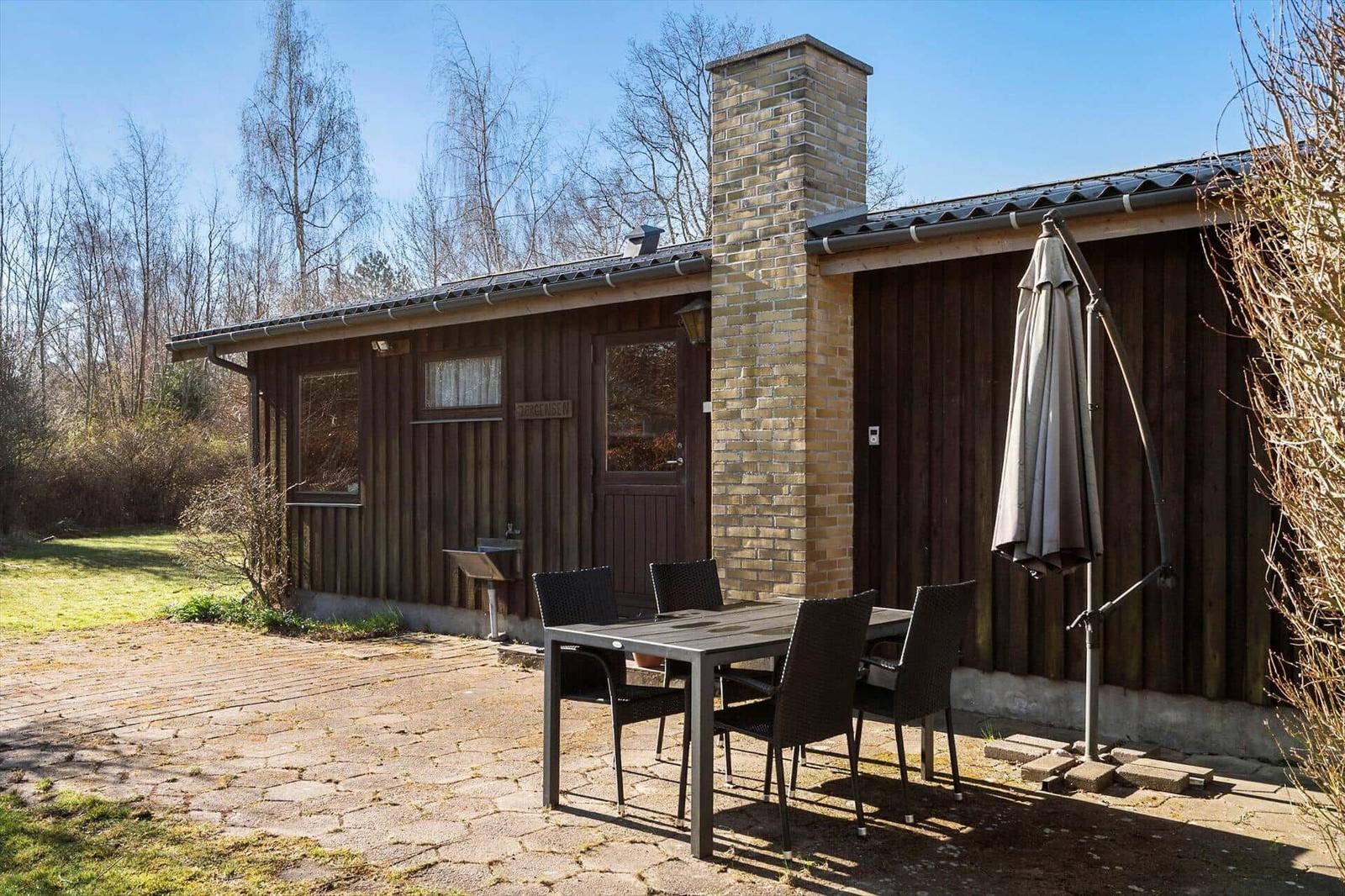 Holzhaus mit Grillplatz und Sitzgruppe im Freien