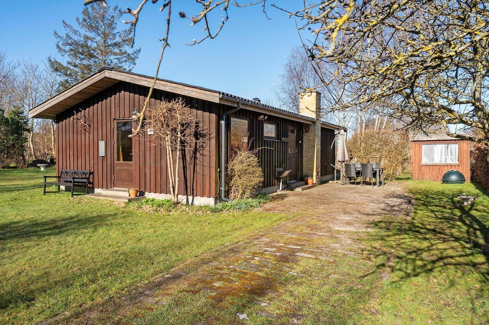Holzhaus mit Terrasse, Garten und Grill. Außendusche und Sitzgelegenheiten.