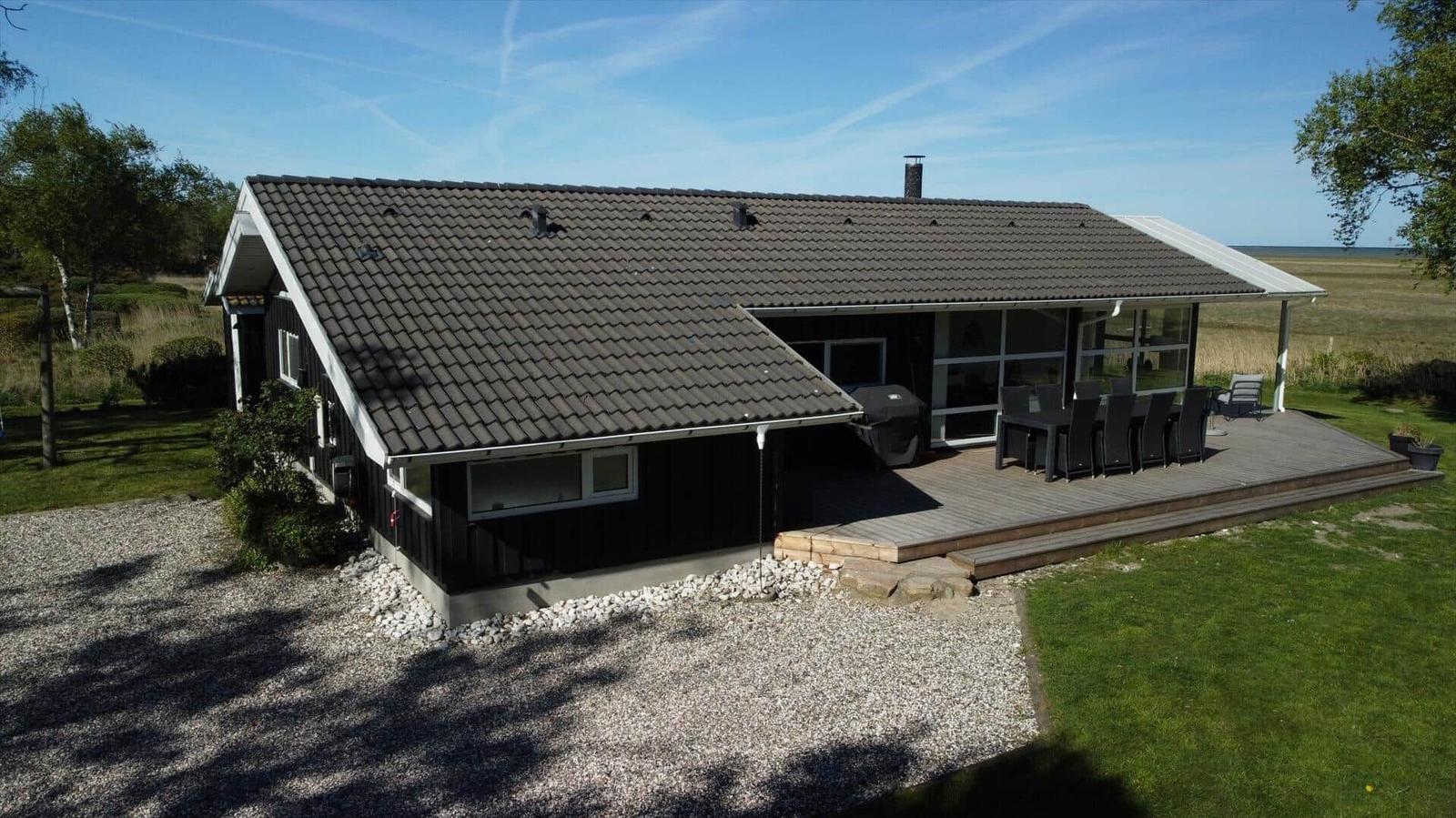 Ein Haus mit Terrasse, Grill und Blick auf das Meer.