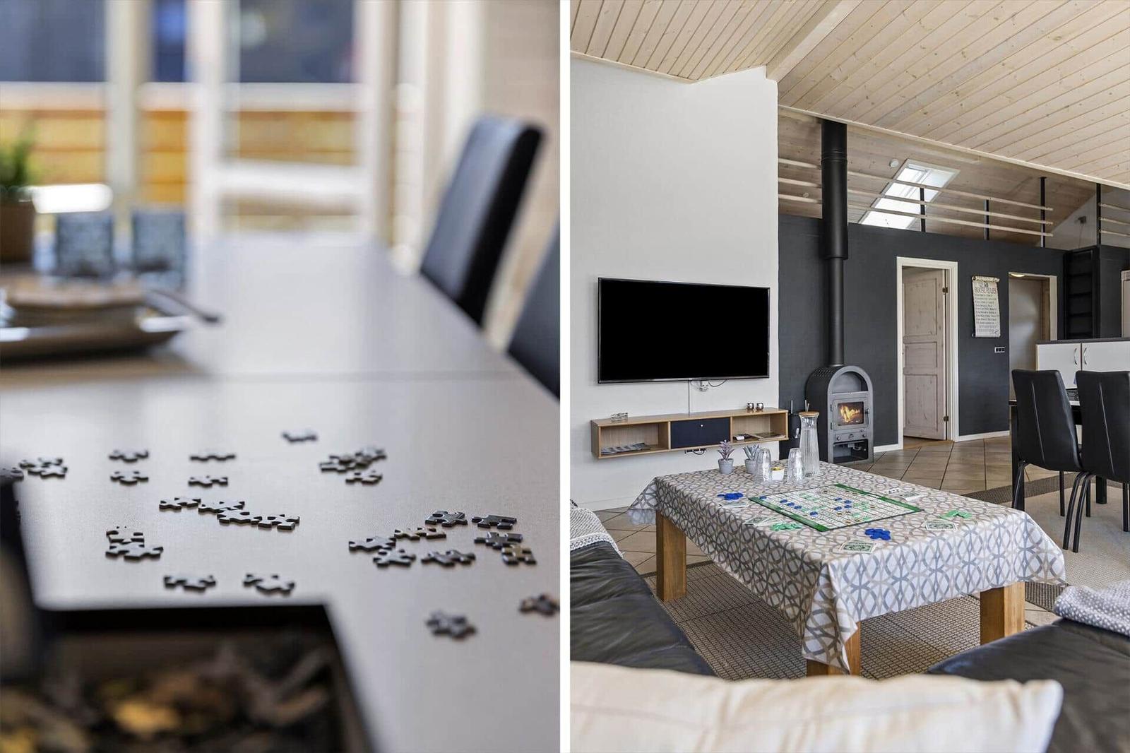Tisch mit Puzzlestücken und Wohnzimmer mit Kamin und Fernseher.