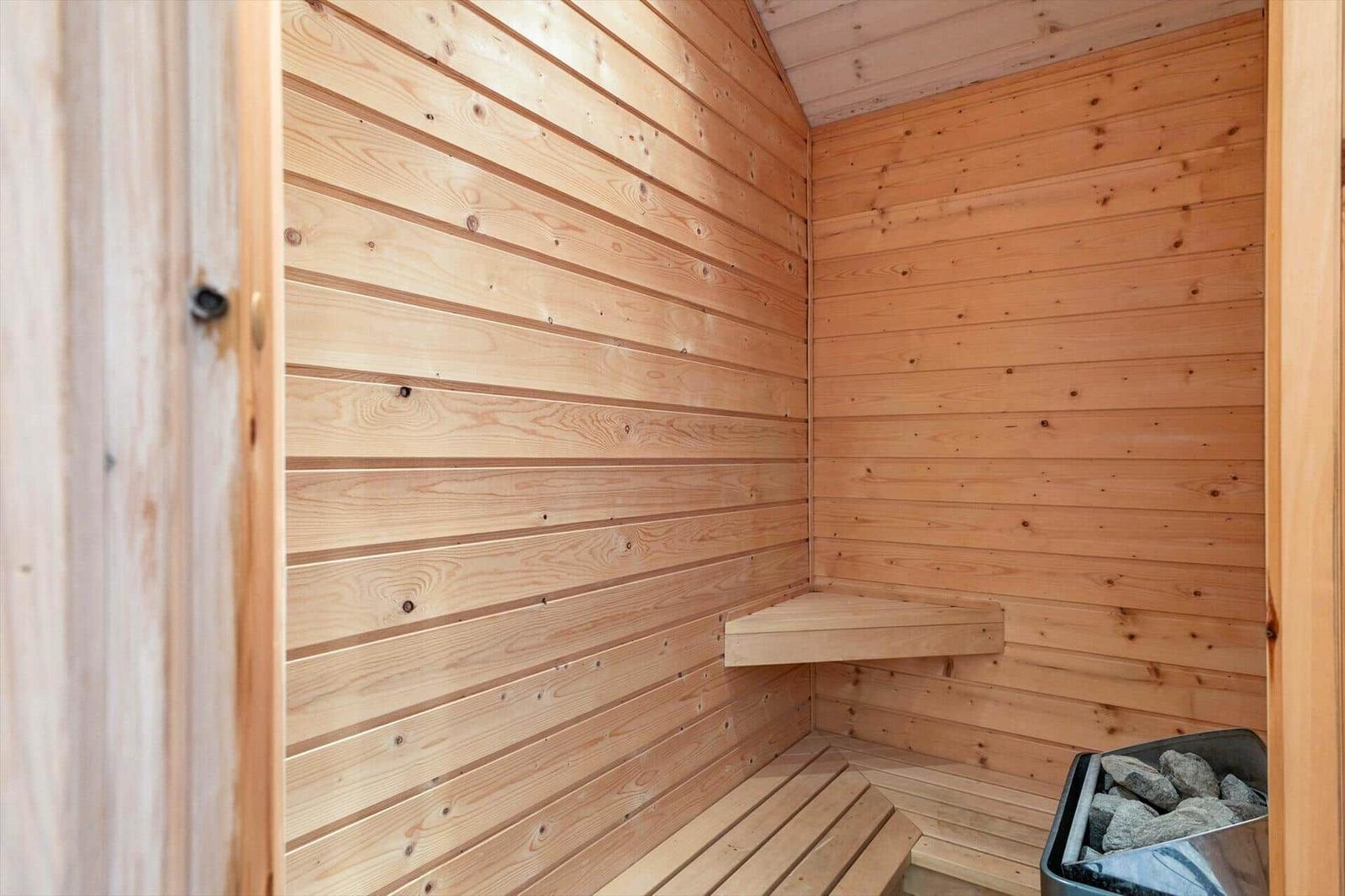 Holzsauna mit Sitzbänken und Steinkasten