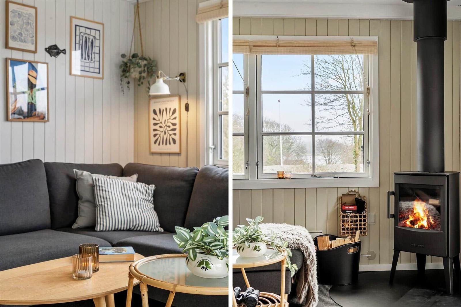 Wohnzimmer mit Sofa, Tischen und Fenster. Kamin mit brennendem Holz.
