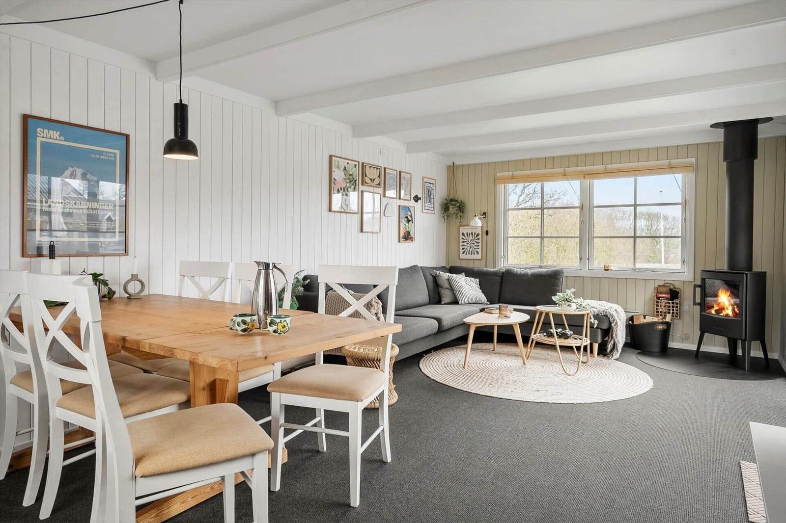 Ein Essbereich mit Tisch und Stühlen neben einem Wohnbereich mit Sofa und Kamin.