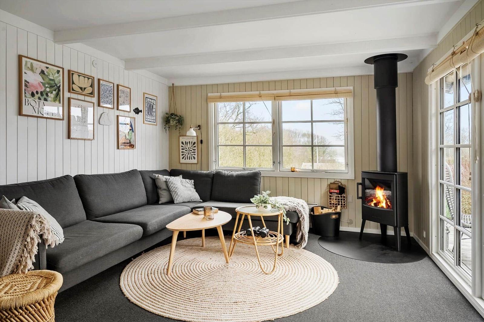 Wohnzimmer mit grauem Sofa, Kamin und Rundteppich