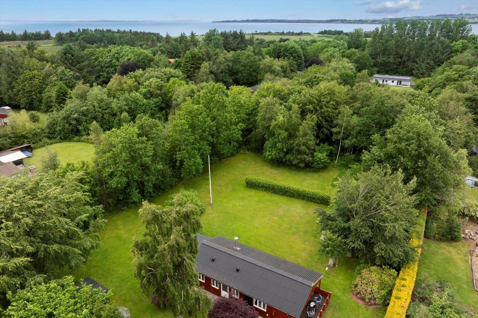 Rotes Haus mit Garten und Wald, Blick auf See