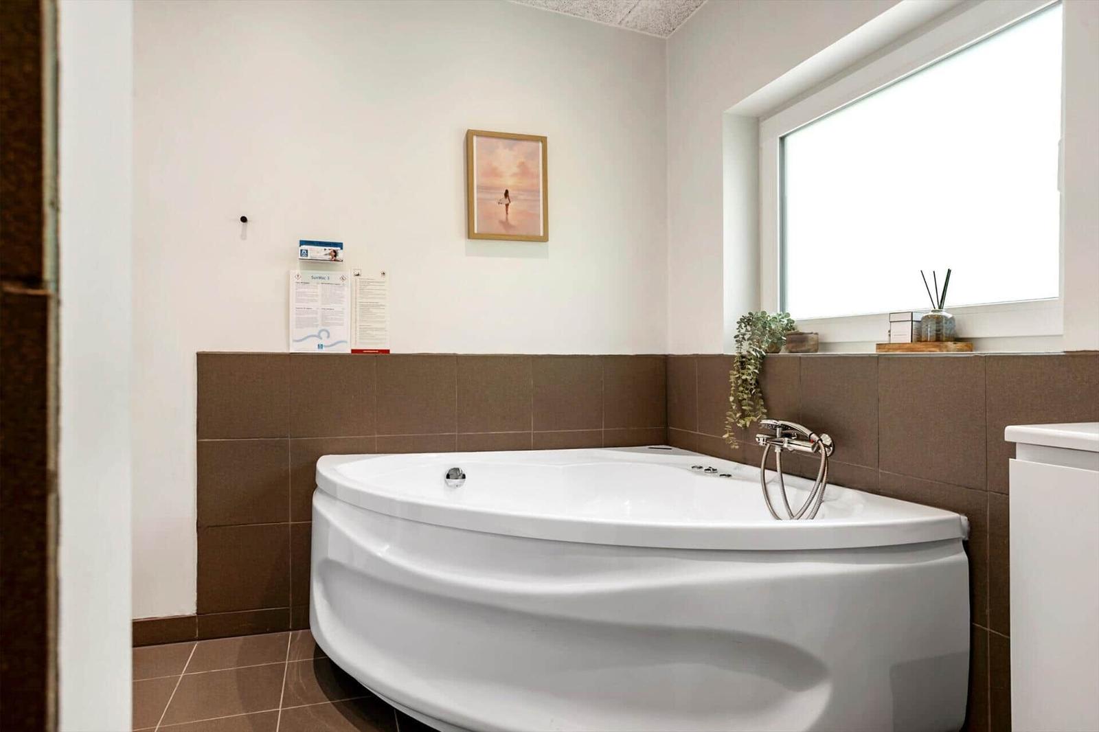 Eckbadewanne mit Duschbrause und Fenster