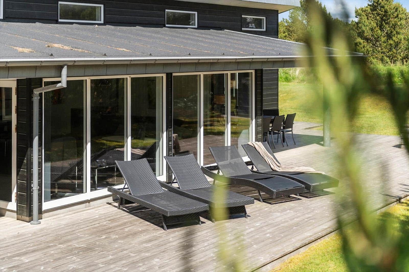 Terrasse mit Liegen und Glasfront zur Wohnung